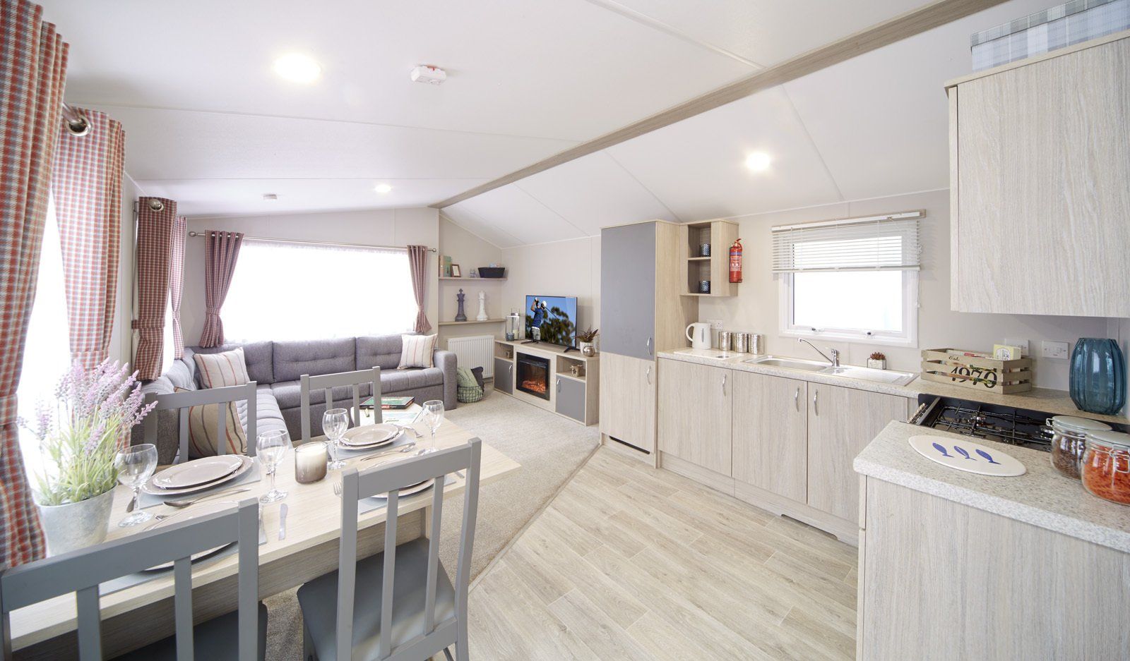 A living room with a dining table and chairs and a kitchen.