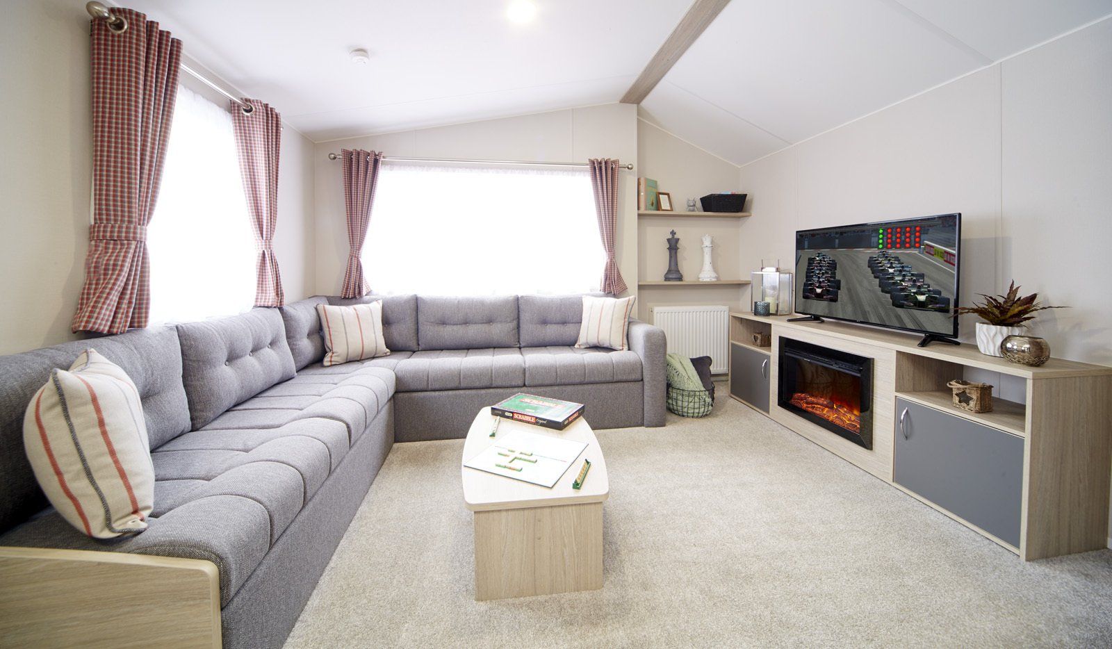 A living room with a couch , table , television and fireplace.