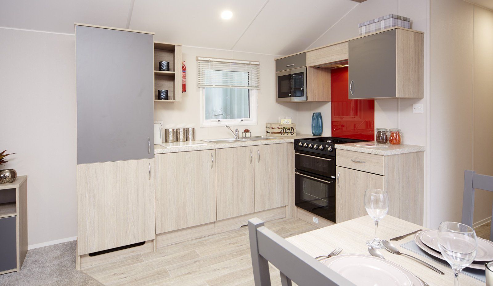 A kitchen in a mobile home with a table and chairs.