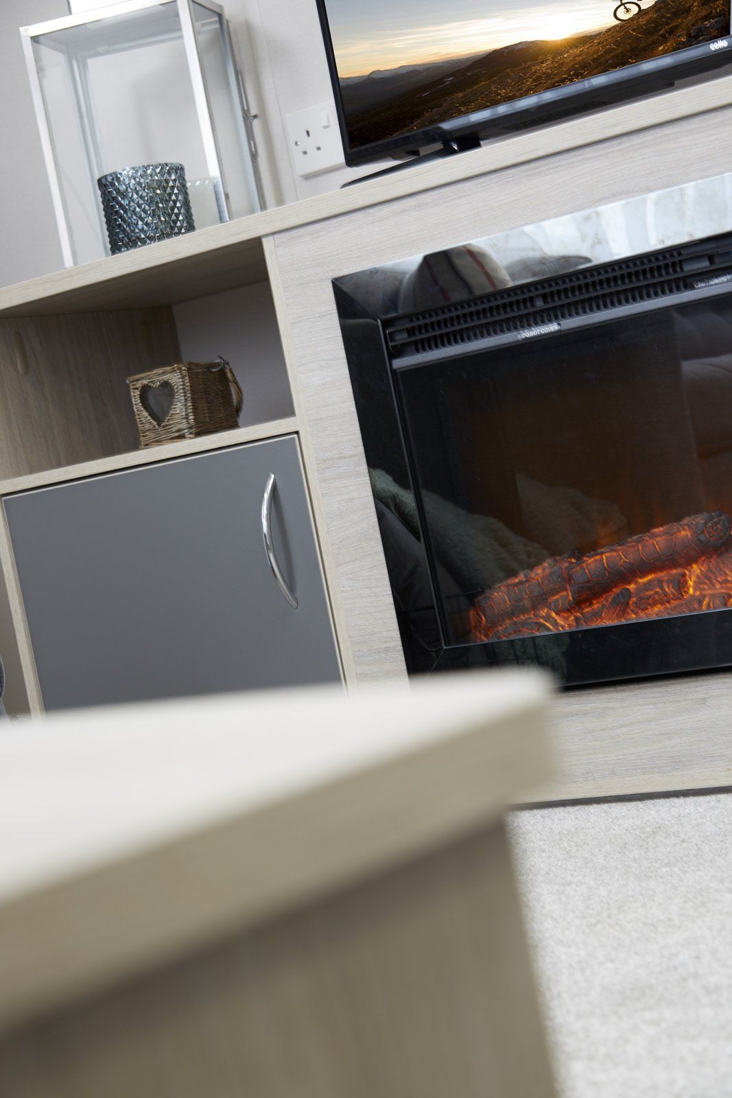 A living room with a fireplace and a television.