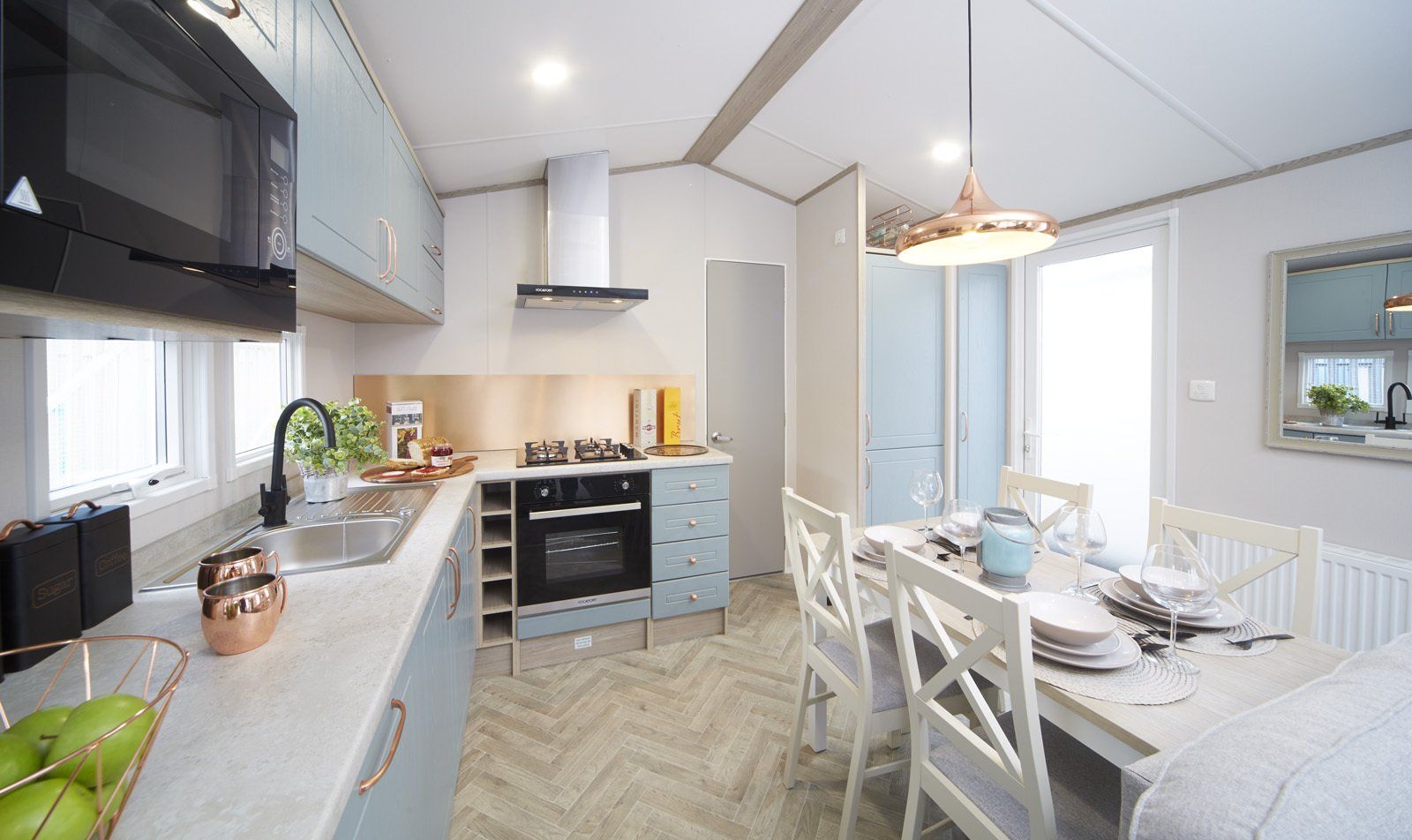 A kitchen and dining room in a mobile home with a table and chairs.