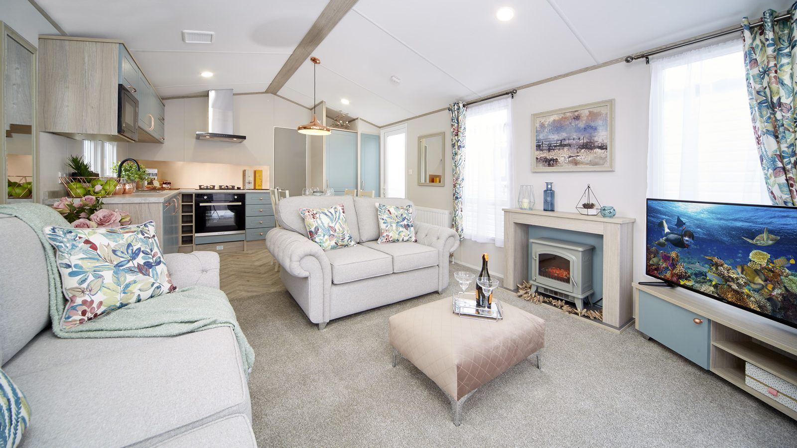 A living room with a couch , coffee table , television and fireplace.