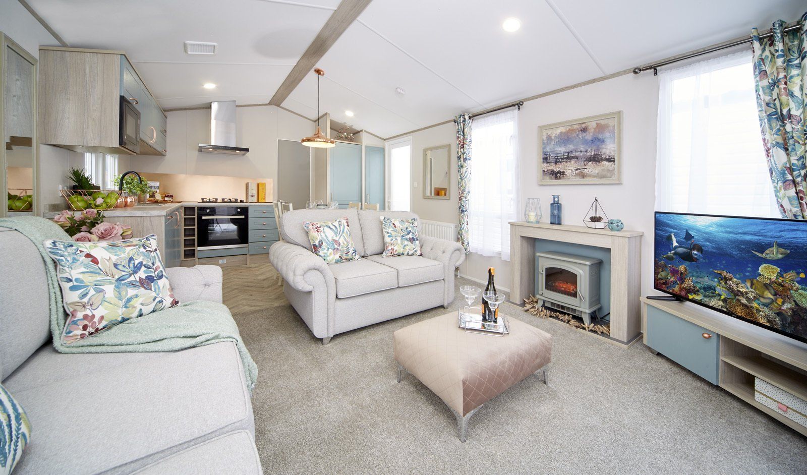 A living room with a couch , table , television and fireplace.