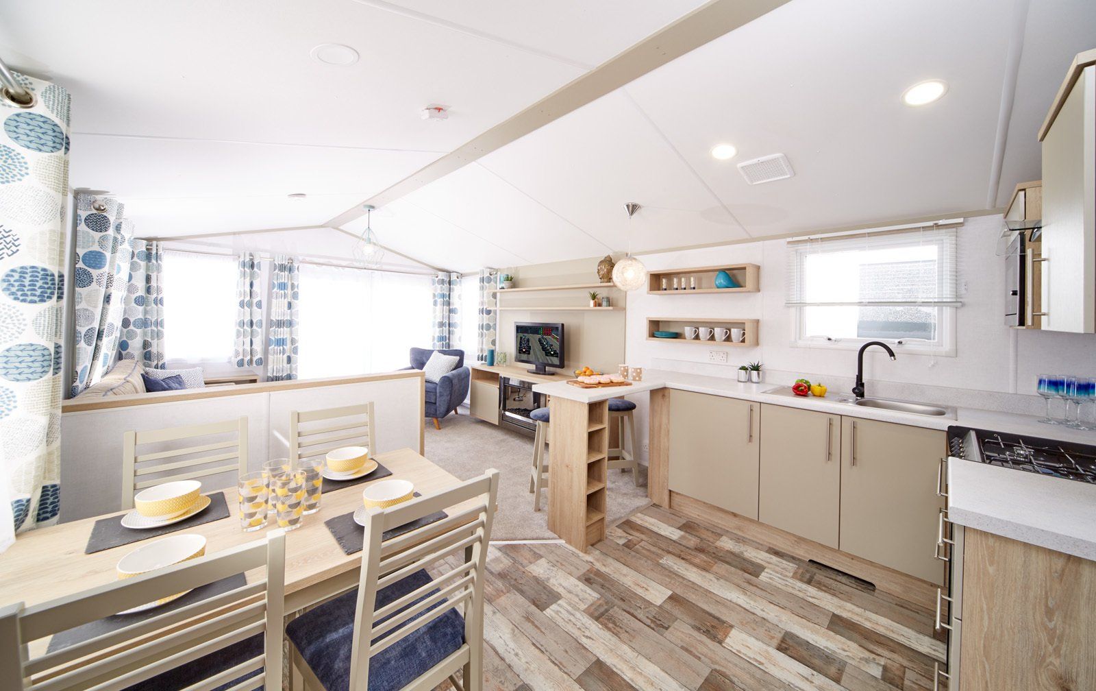 A kitchen and dining room in a mobile home with a table and chairs.