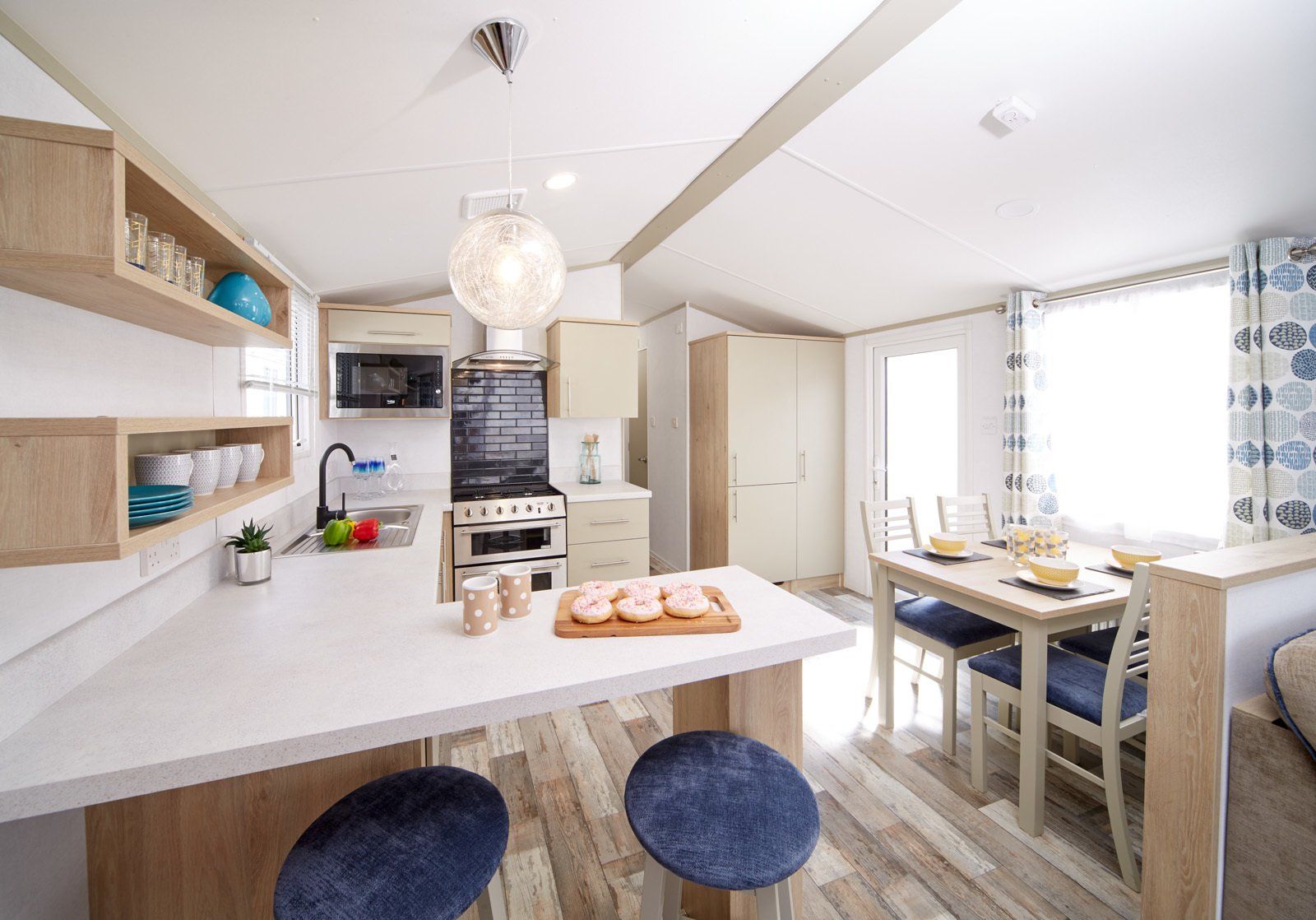 A kitchen and dining room in a mobile home with a table and chairs.