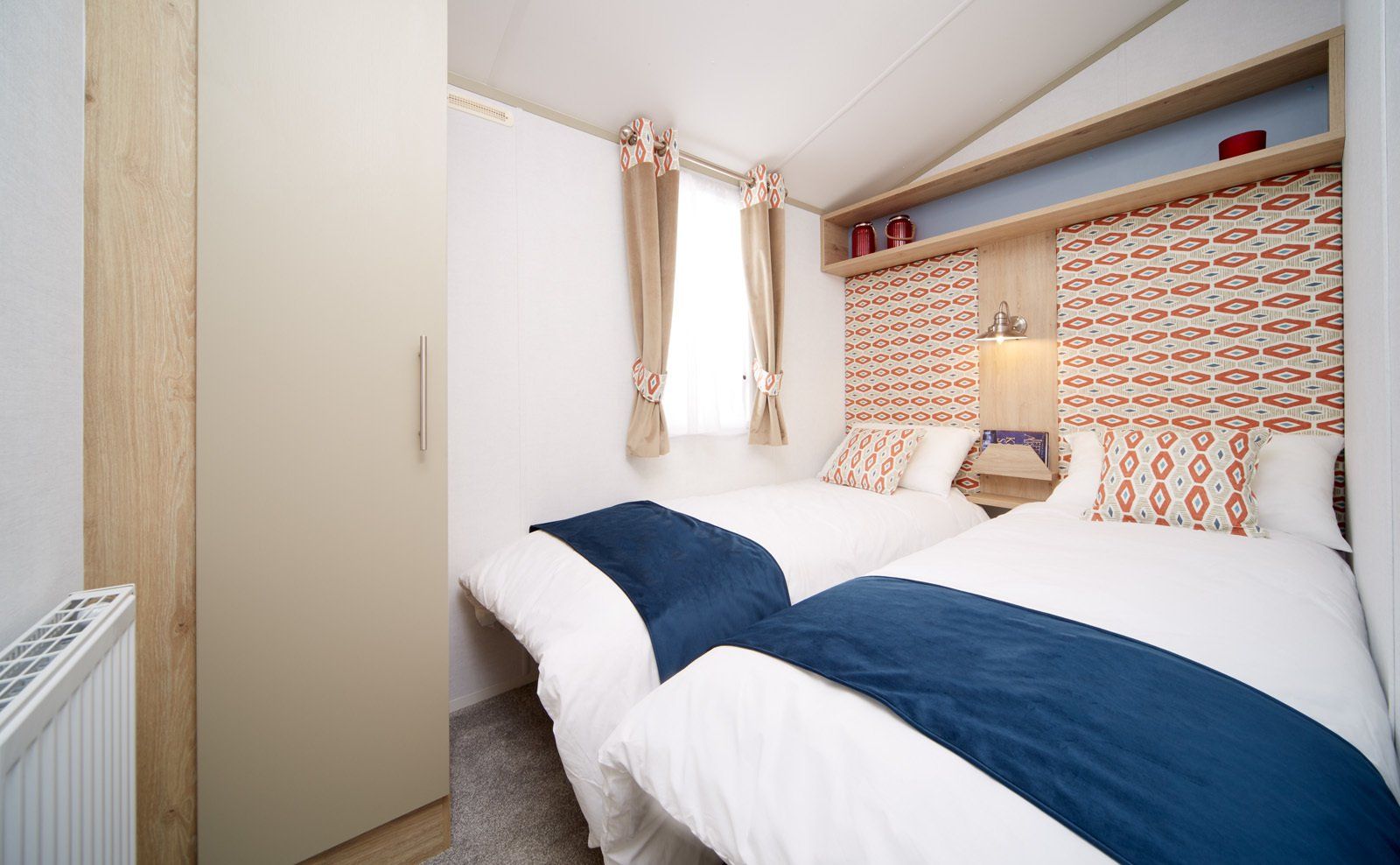 A bedroom with two beds and a window.
