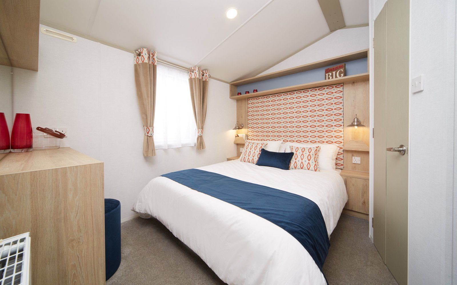 A bedroom with a large bed and a window.