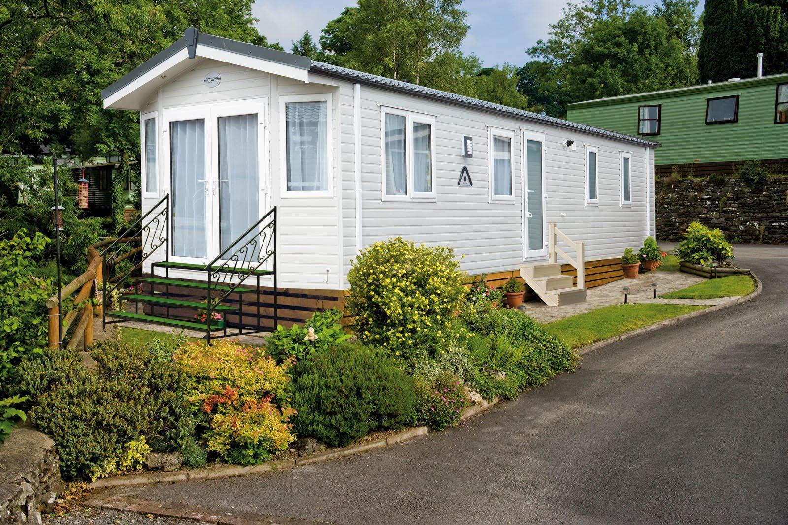 A white mobile home is parked on the side of a road.