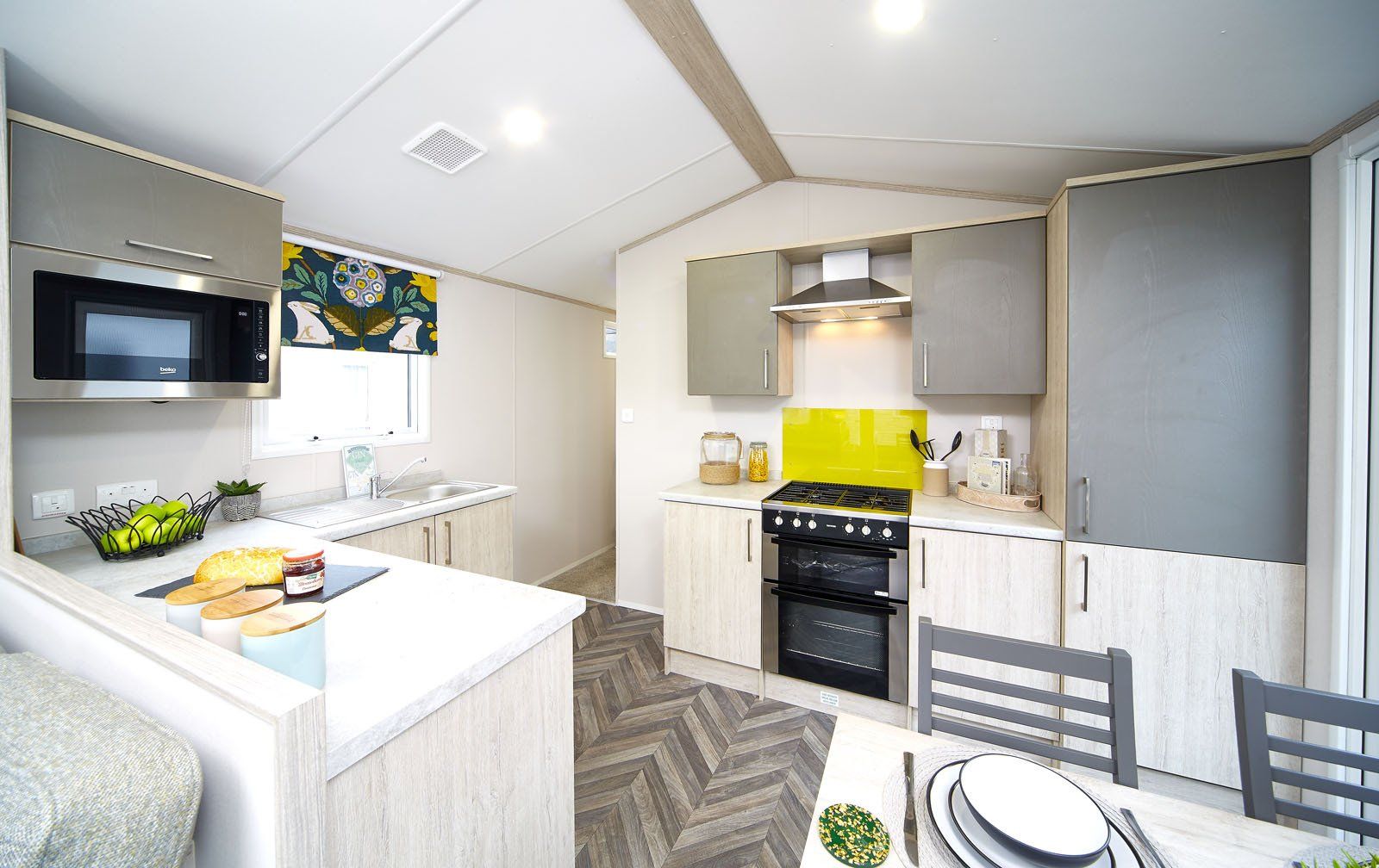 A kitchen and dining room in a mobile home with a table and chairs.