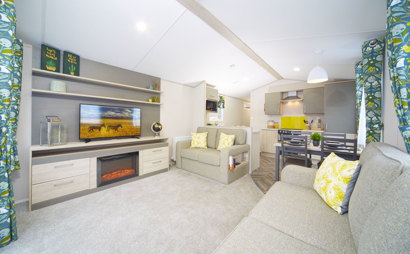 A living room with a couch , chair , television and fireplace.