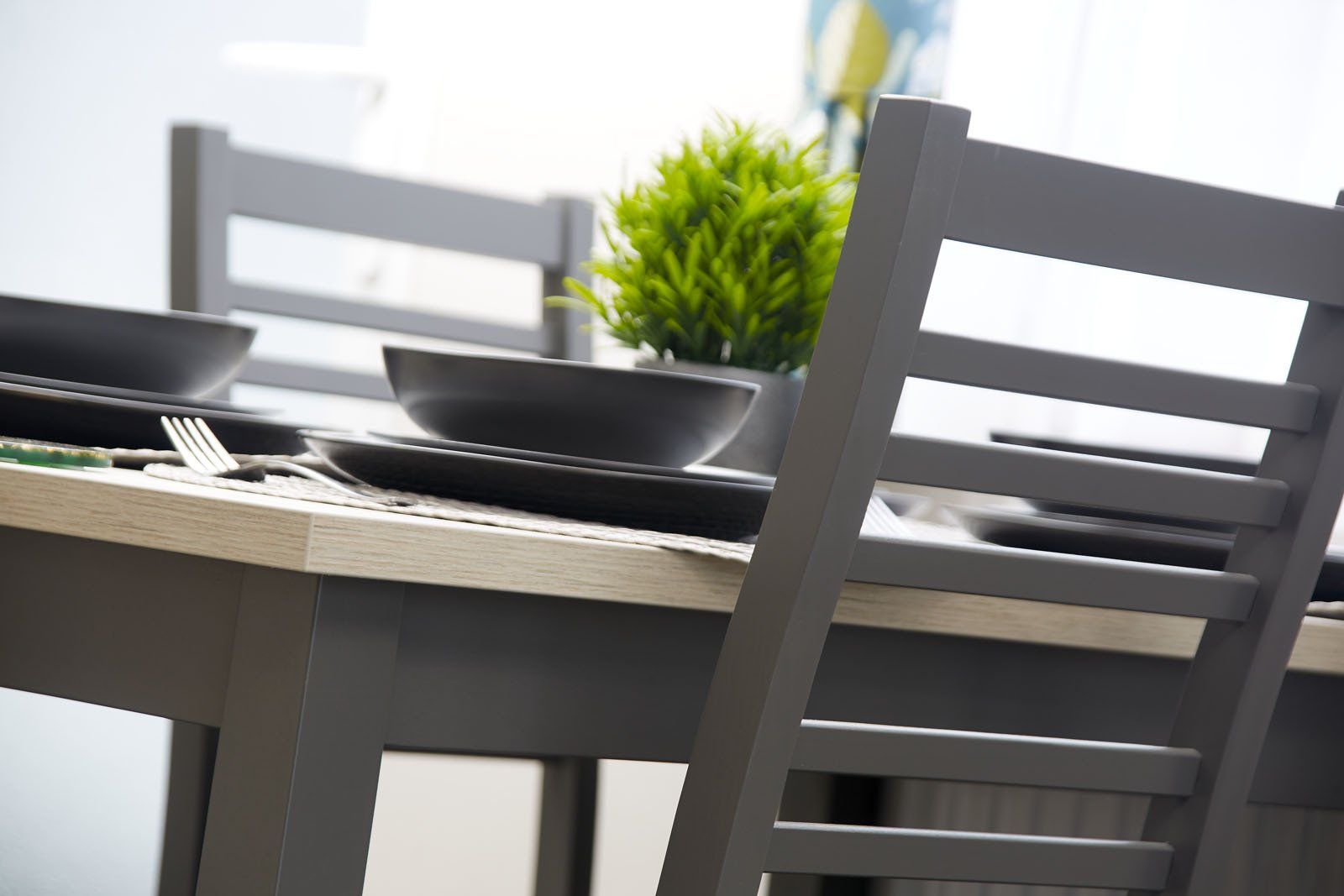 A dining room table with plates and bowls on it