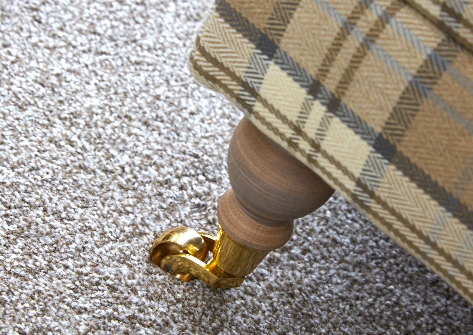 A close up of a plaid chair on a carpet