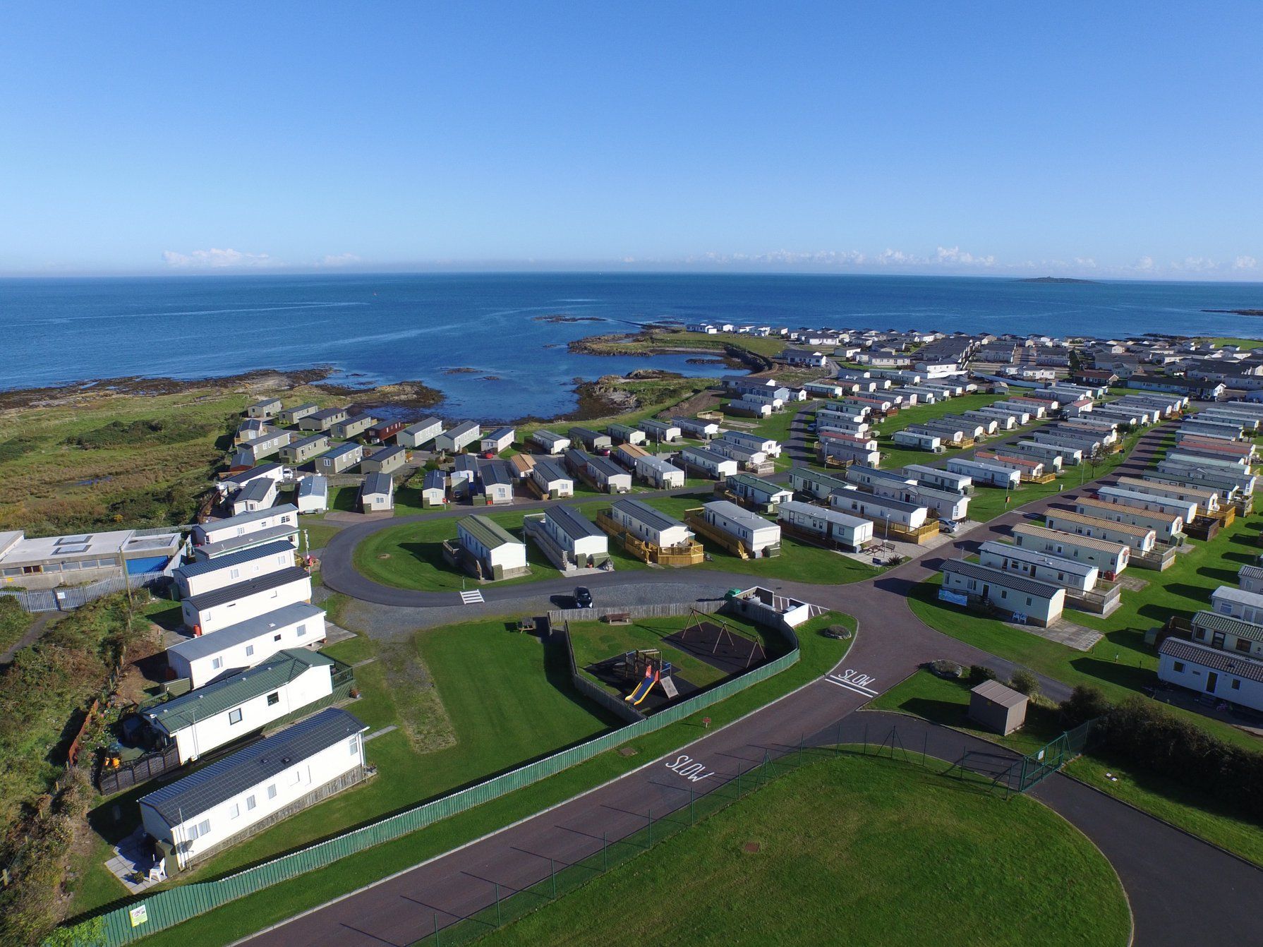 An aerial view of a caravan park next to the ocean.