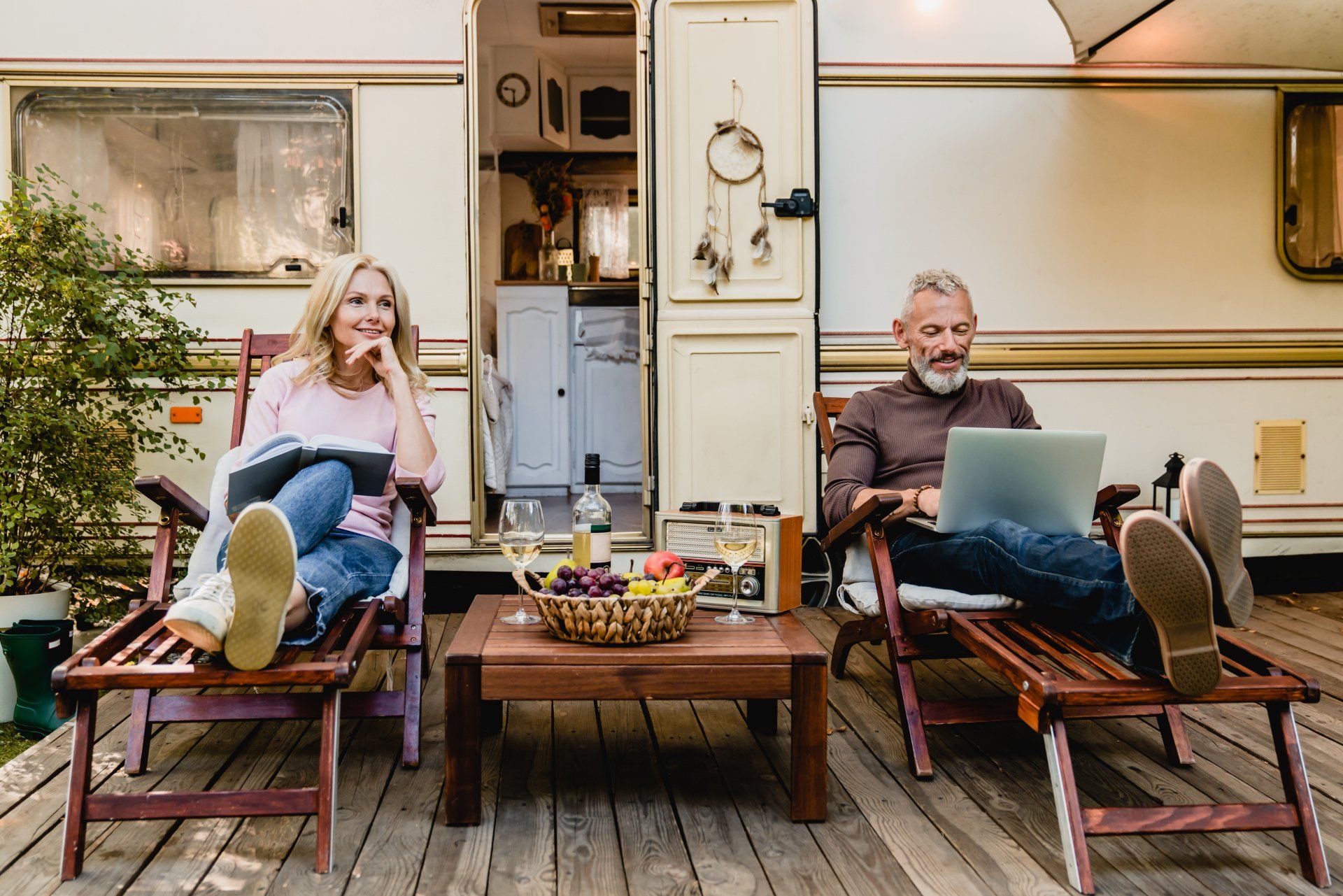 An elderly couple enjoying an afternoon on the decking of their caravan