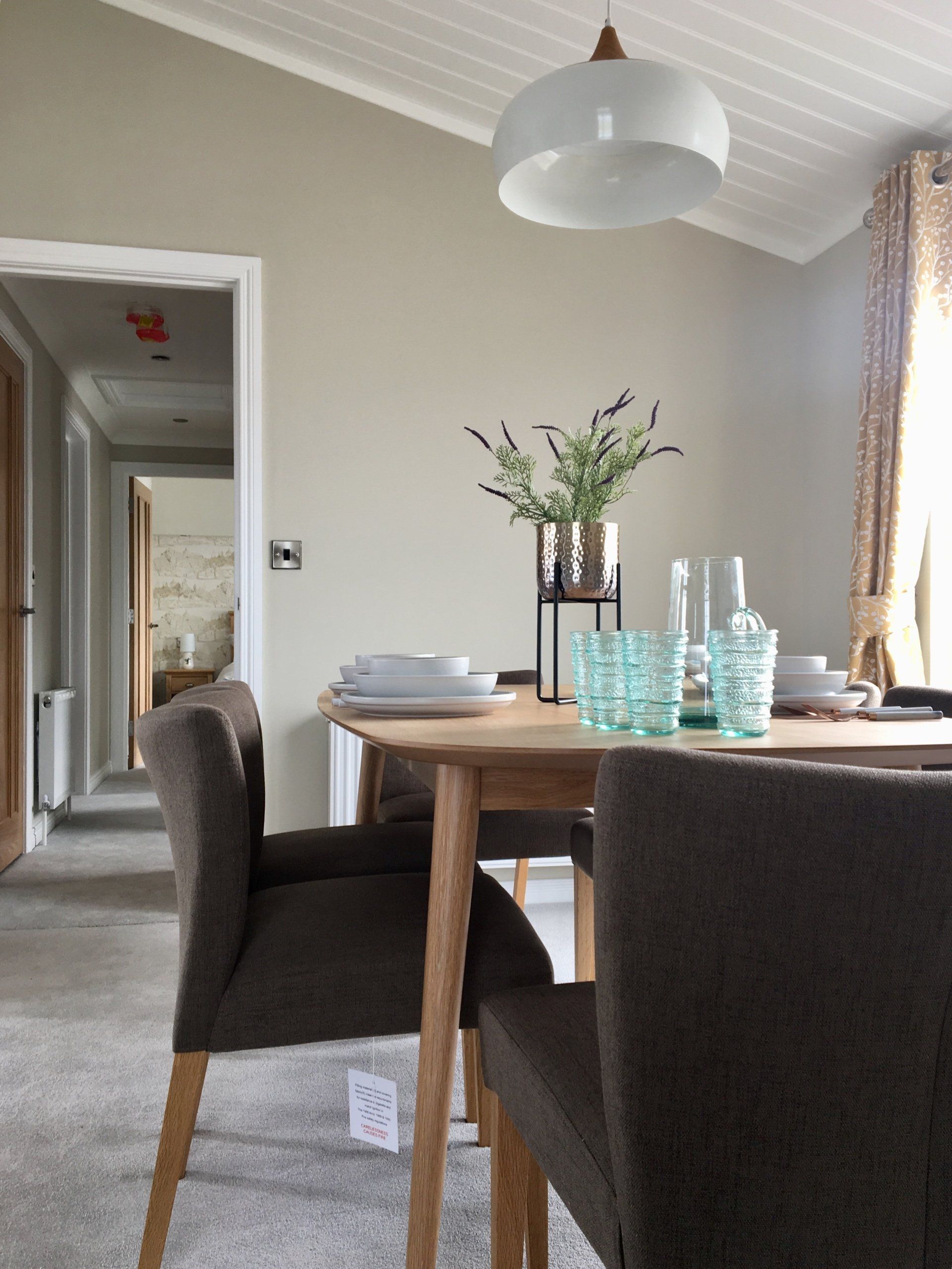 A dining room with a table and chairs and glasses on it