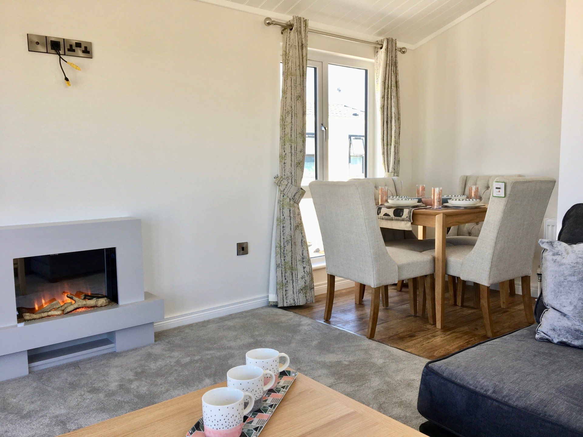 A living room with a fireplace , dining table and chairs.