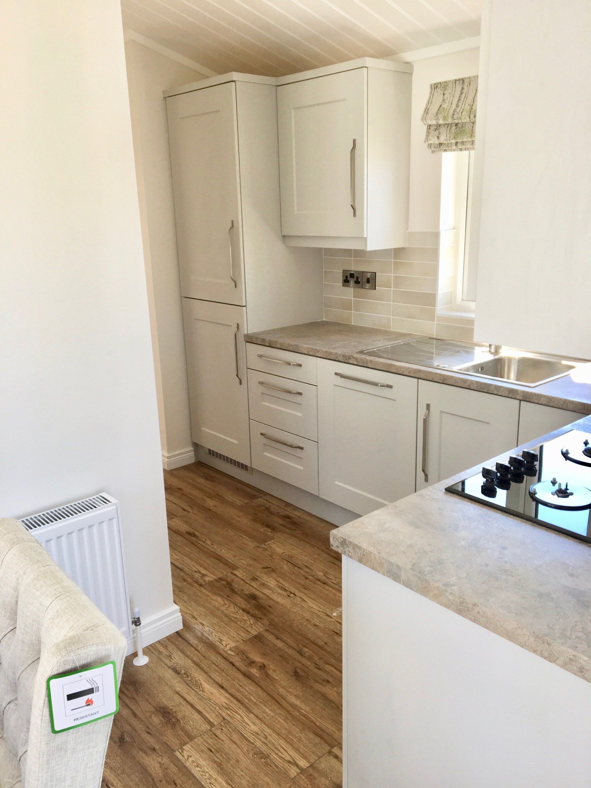 A kitchen with white cabinets and a stove top oven.