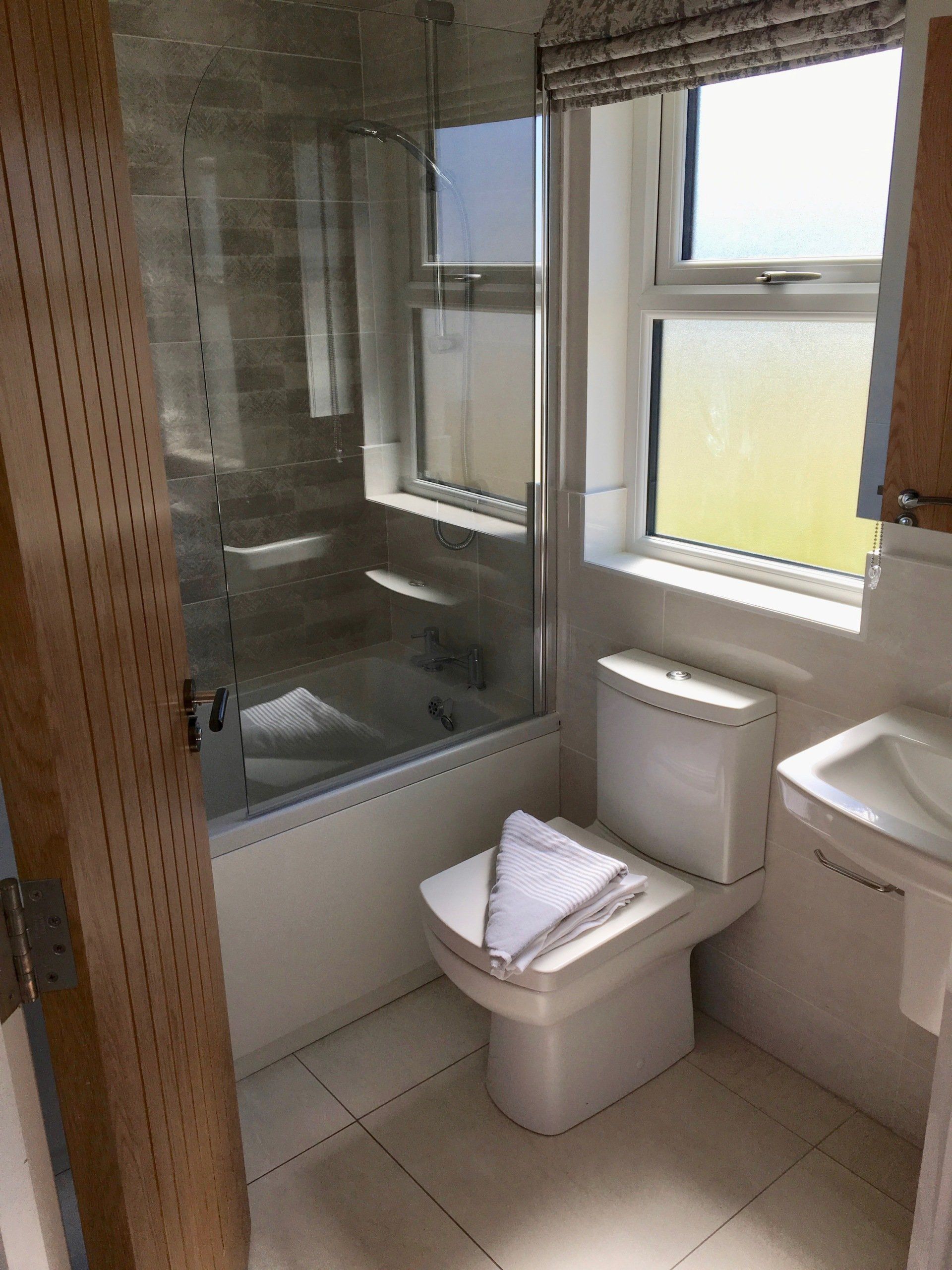 A bathroom with a toilet , sink and bathtub.