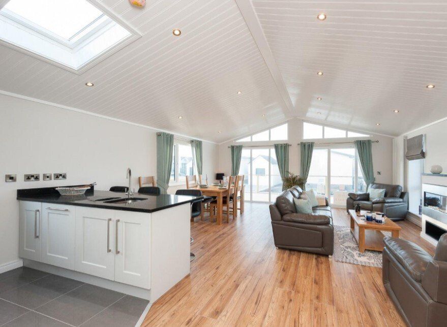 A living room with hardwood floors and a kitchen