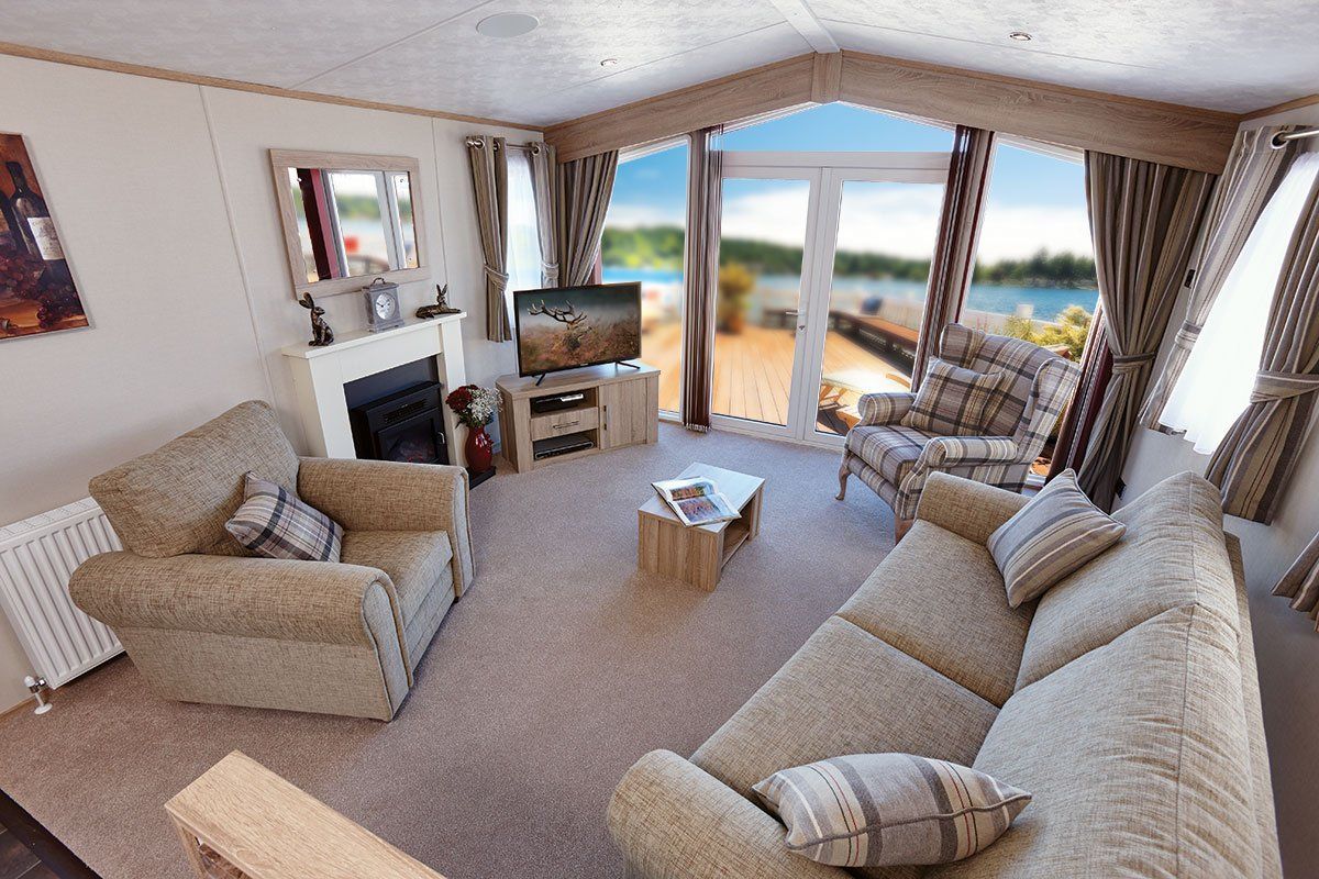 A living room with a couch , chairs , television and fireplace.