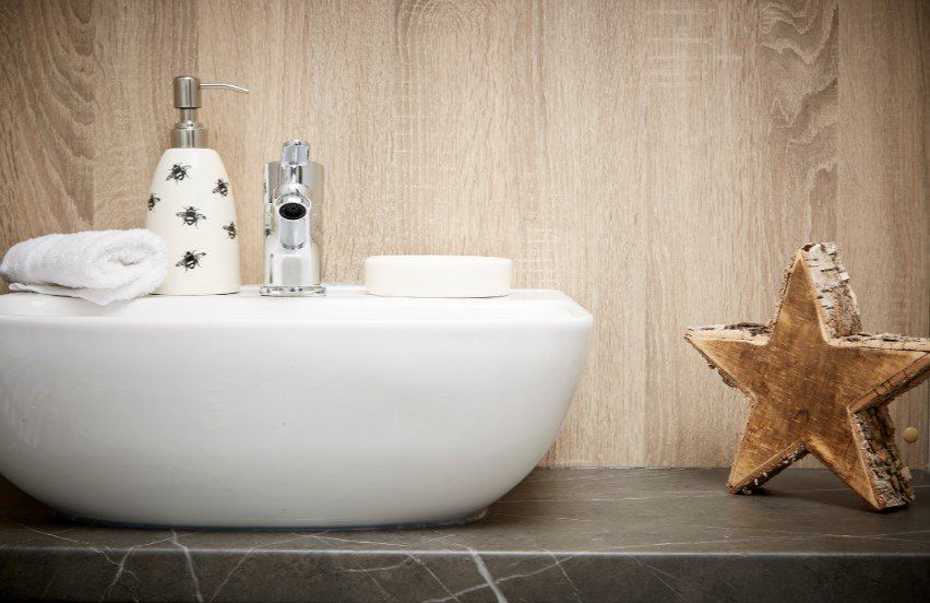 A bathroom sink with a soap dispenser and a starfish on the counter.