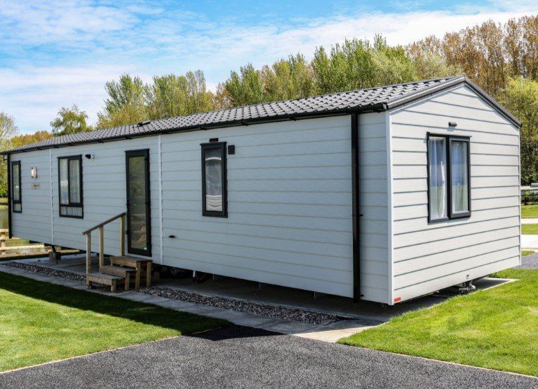 A mobile home is parked in a grassy field.