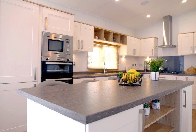 A kitchen with white cabinets and stainless steel appliances