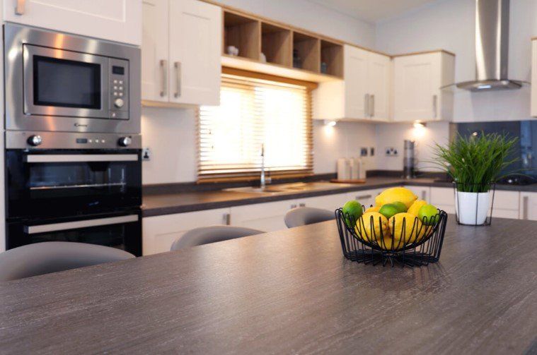 A kitchen with a basket of lemons and limes on the counter