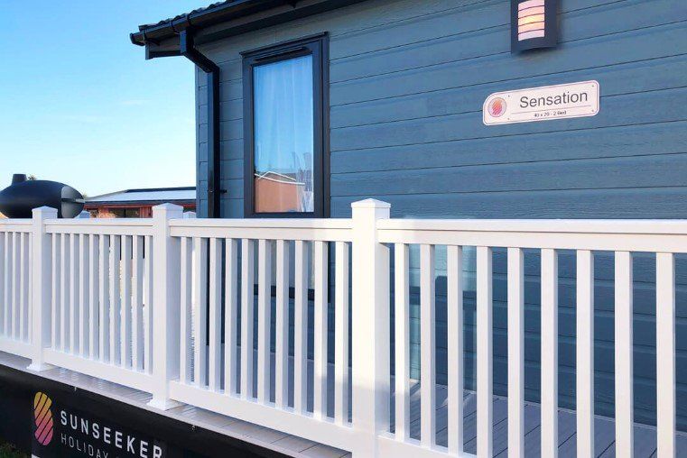 A house with a white railing and a sign that says sunseeker on it.