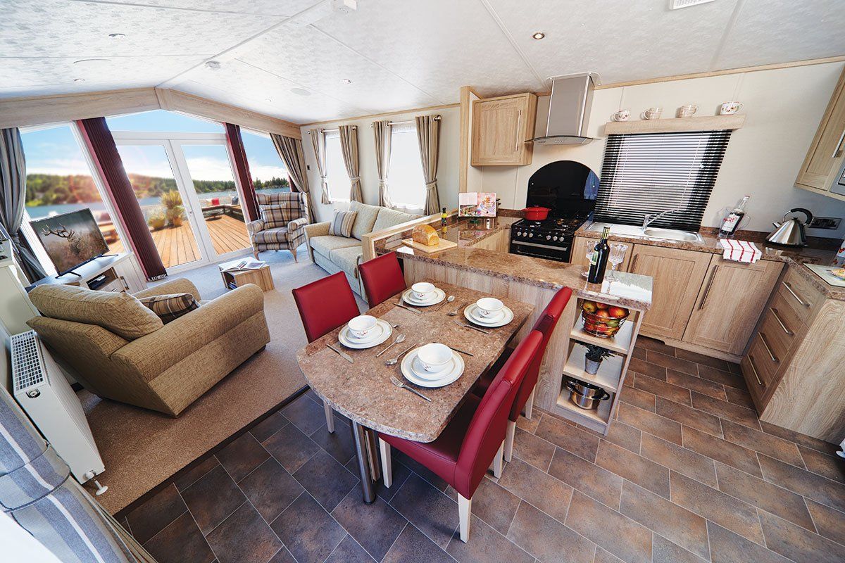 A living room with a dining table and chairs and a kitchen.