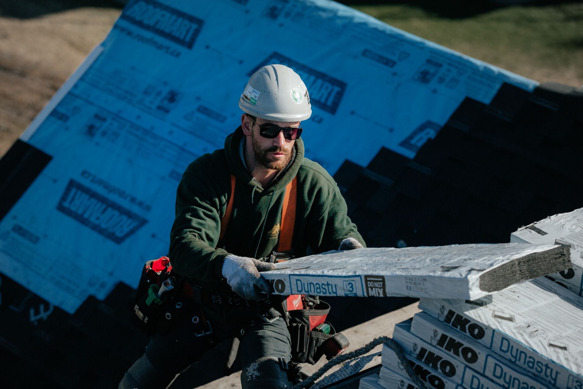 Un homme portant un casque et des lunettes de soleil transporte un gros morceau de béton.