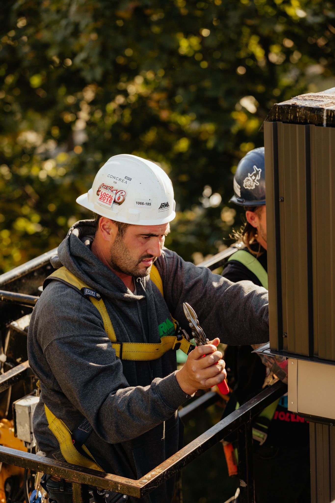 Un homme portant un casque travaille sur une clôture.