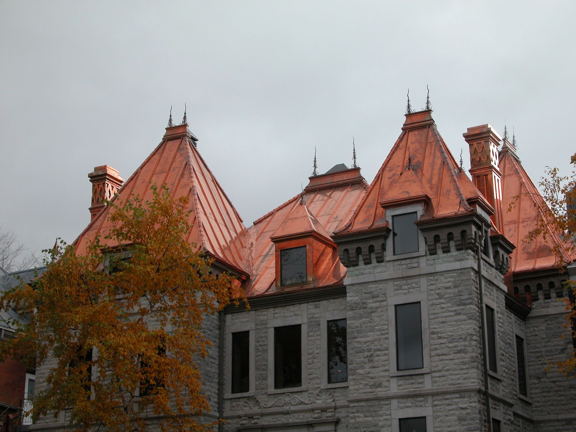 Un grand bâtiment en brique avec des toits et des cheminées en cuivre