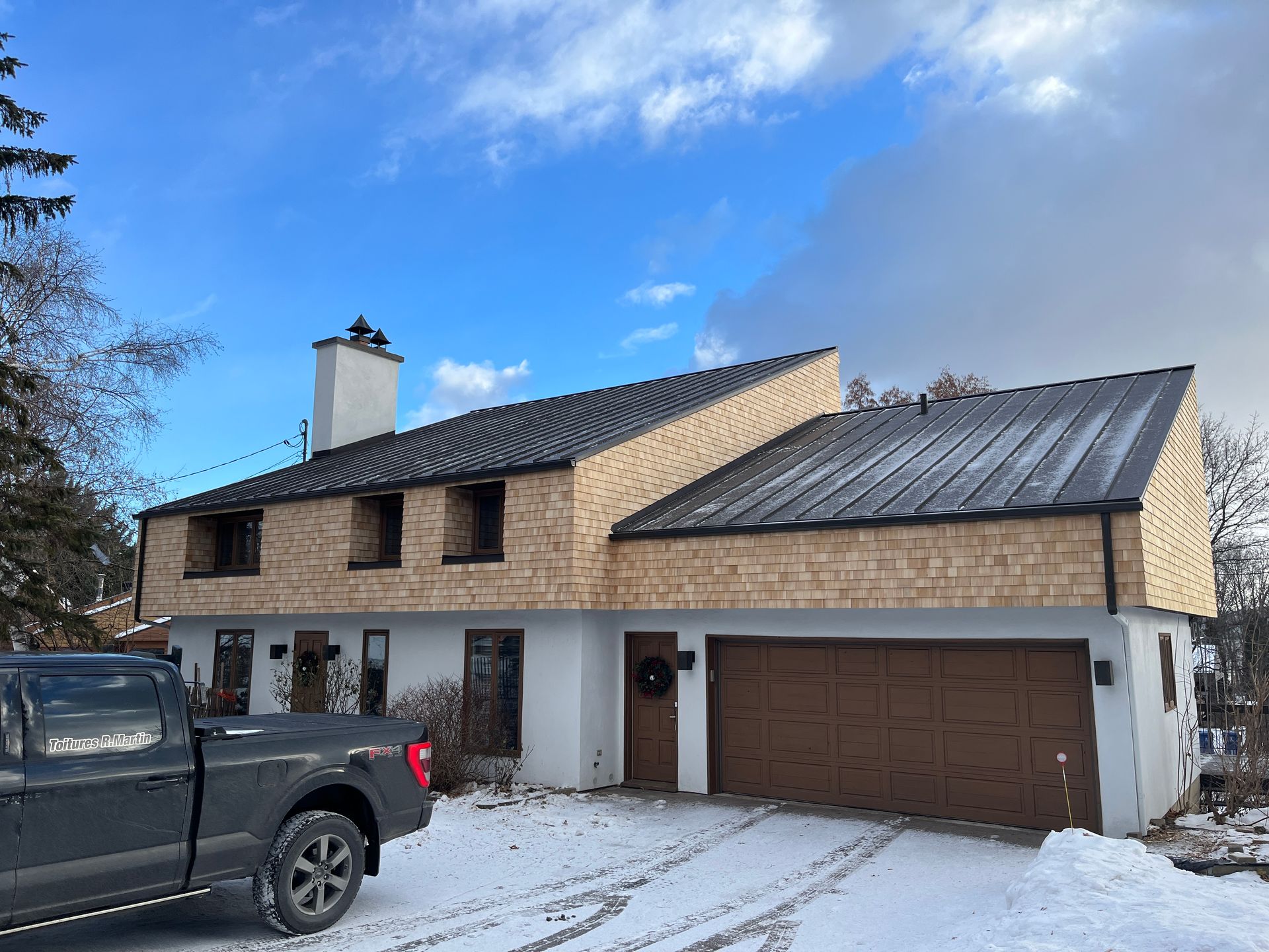 Un camion est garé devant une maison sous la neige.