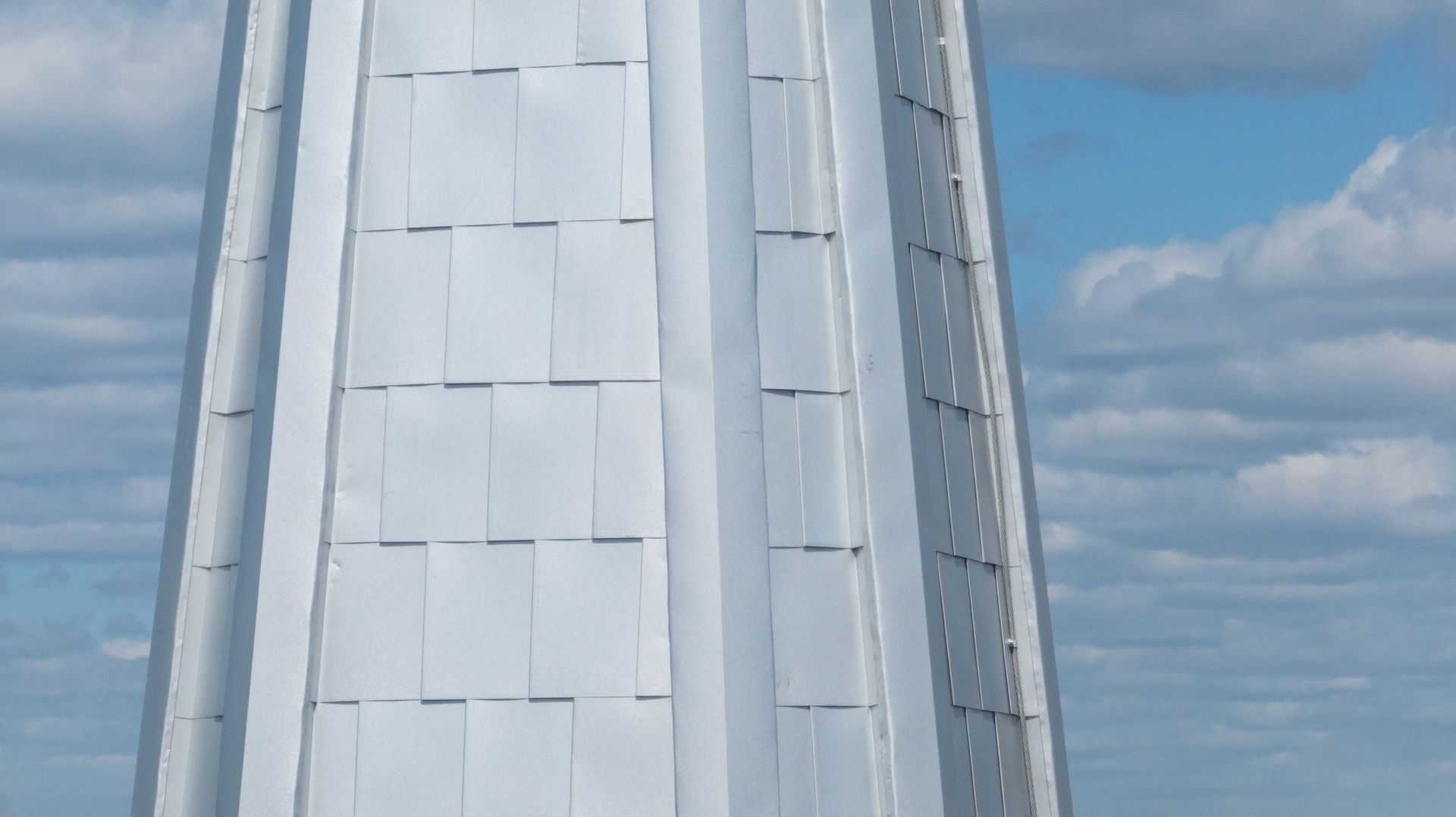Un grand bâtiment blanc avec un ciel bleu en arrière-plan