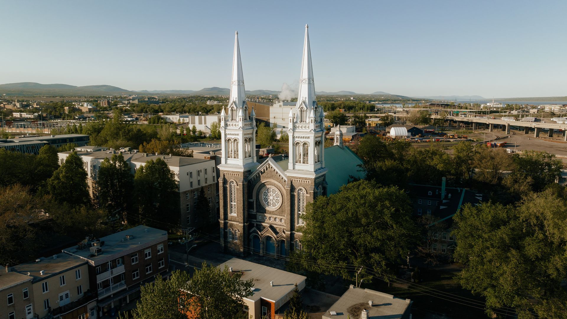 Une vue aérienne d'une grande église entourée d'arbres dans une ville.