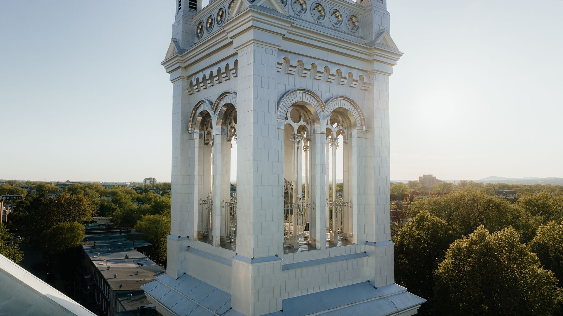 Une vue aérienne d'un grand bâtiment blanc avec un clocher entouré d'arbres.
