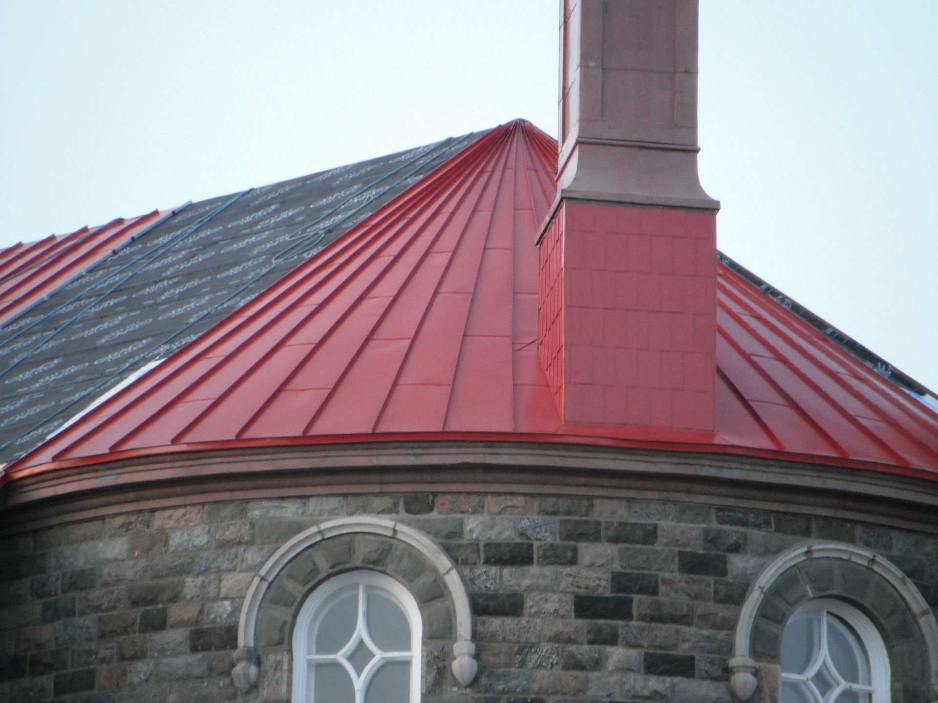 Un bâtiment en brique avec un toit rouge et une cheminée