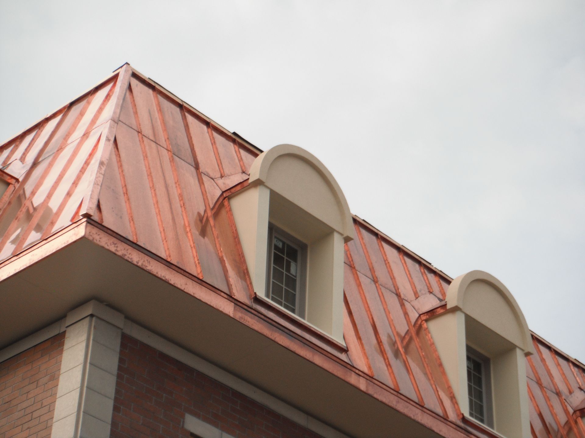 Un bâtiment avec un toit en cuivre et des fenêtres cintrées