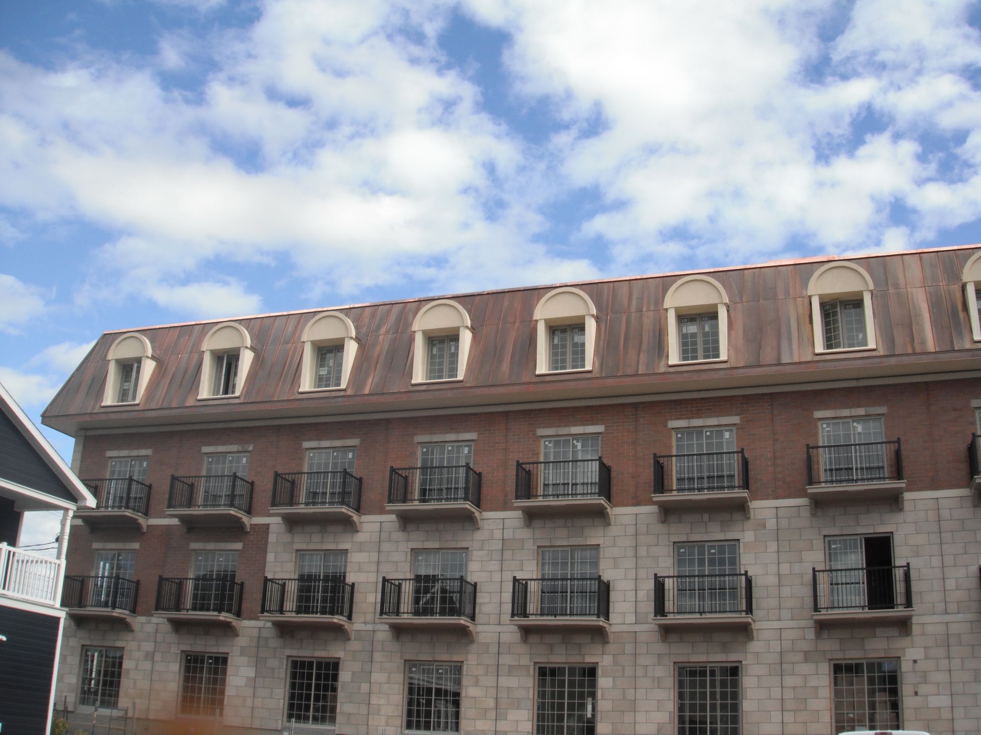 Un grand bâtiment avec un toit qui a beaucoup de fenêtres