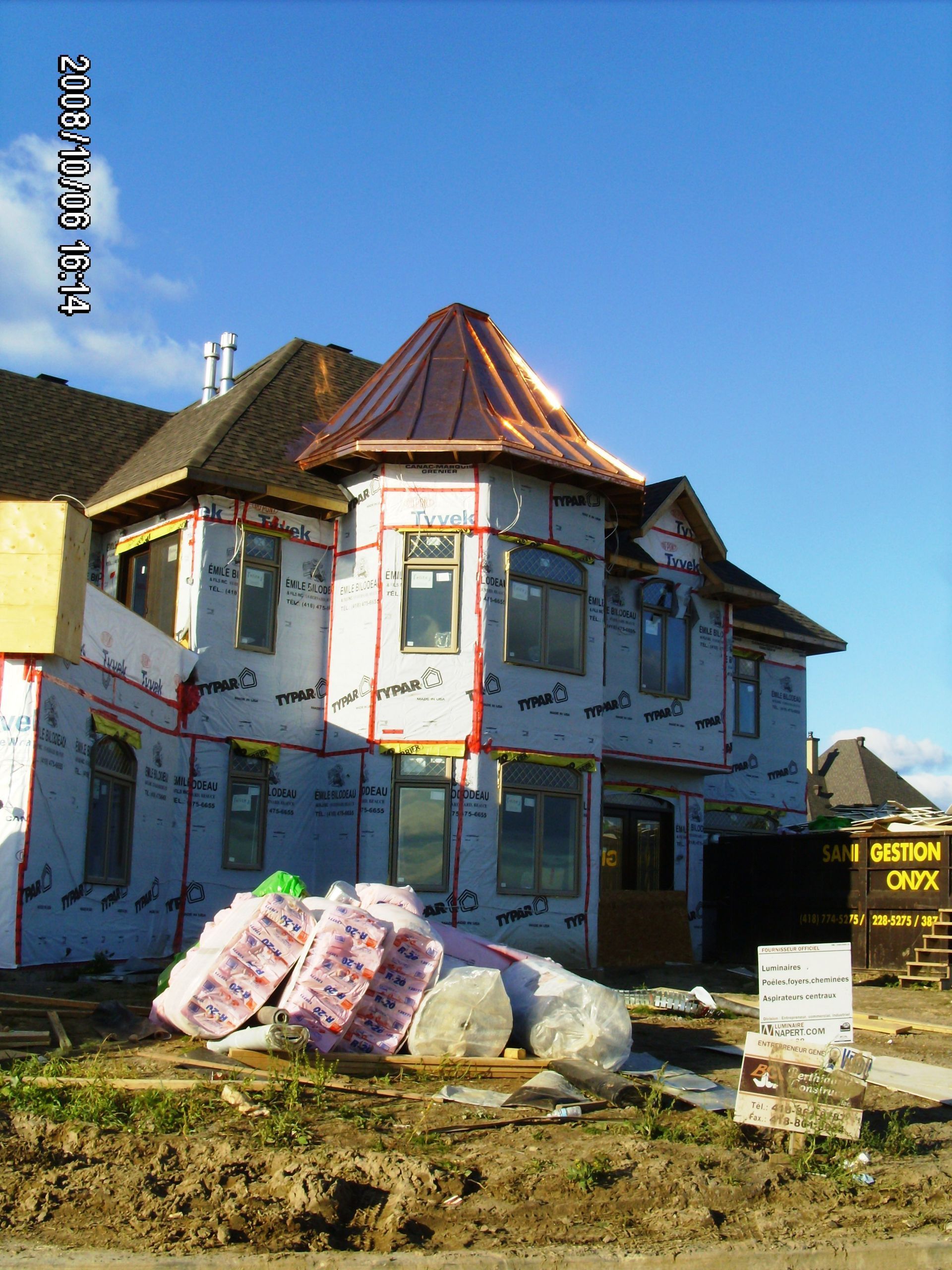 Une grande maison est en construction avec un toit en cuivre