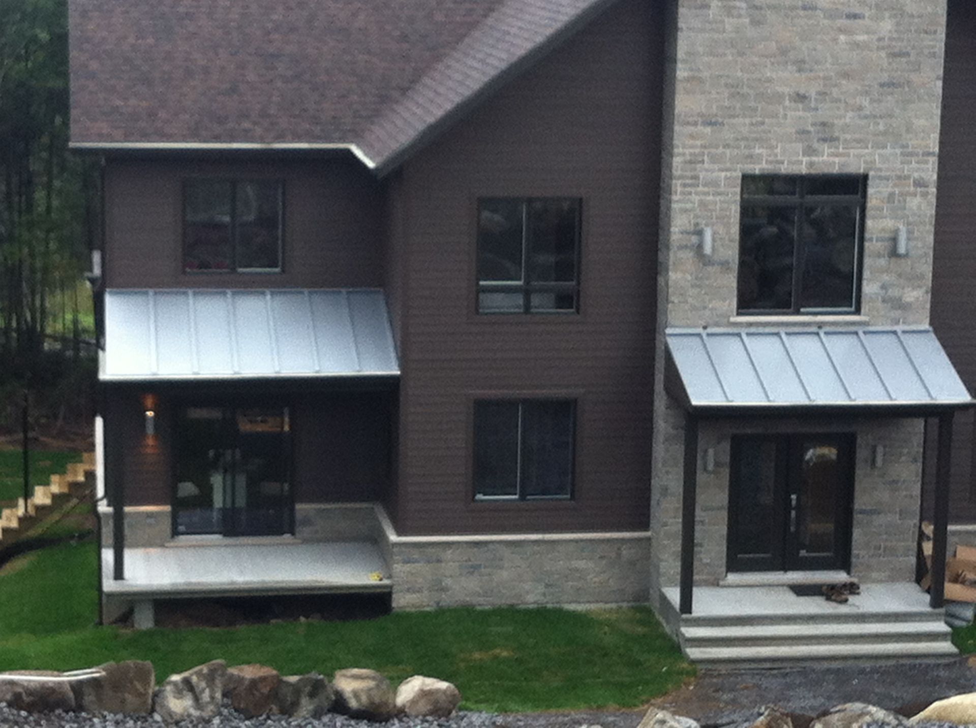 Une grande maison brune avec un toit en métal