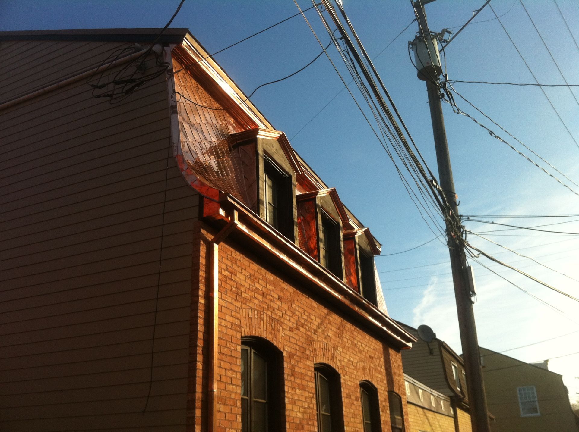 Un bâtiment en brique avec une gouttière en cuivre sur le côté