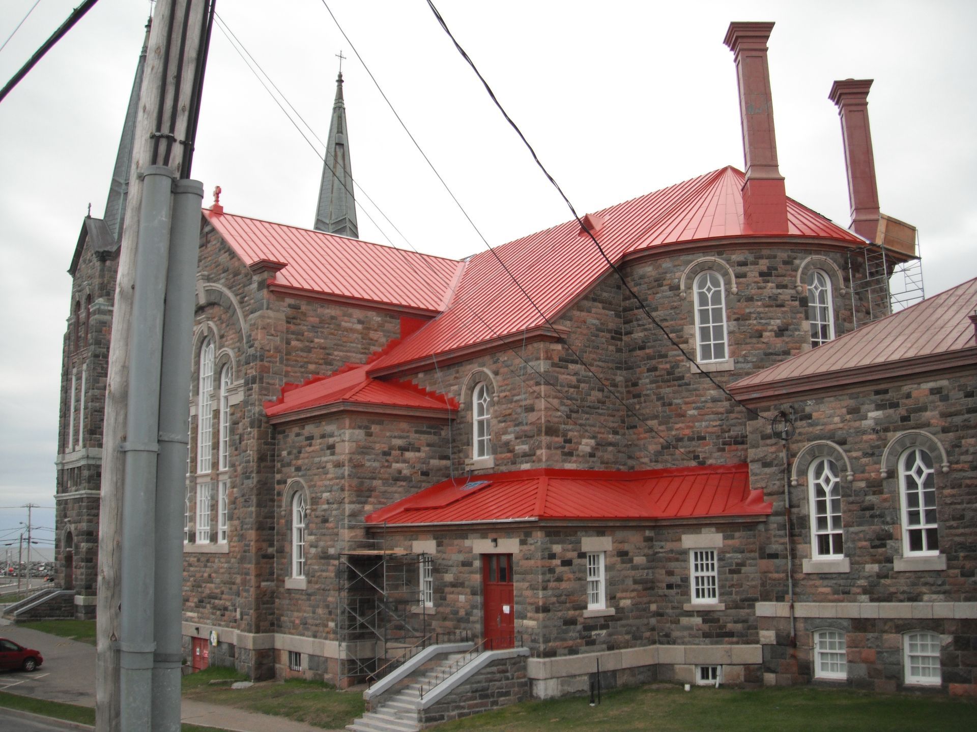 Un grand bâtiment en pierre avec un toit rouge