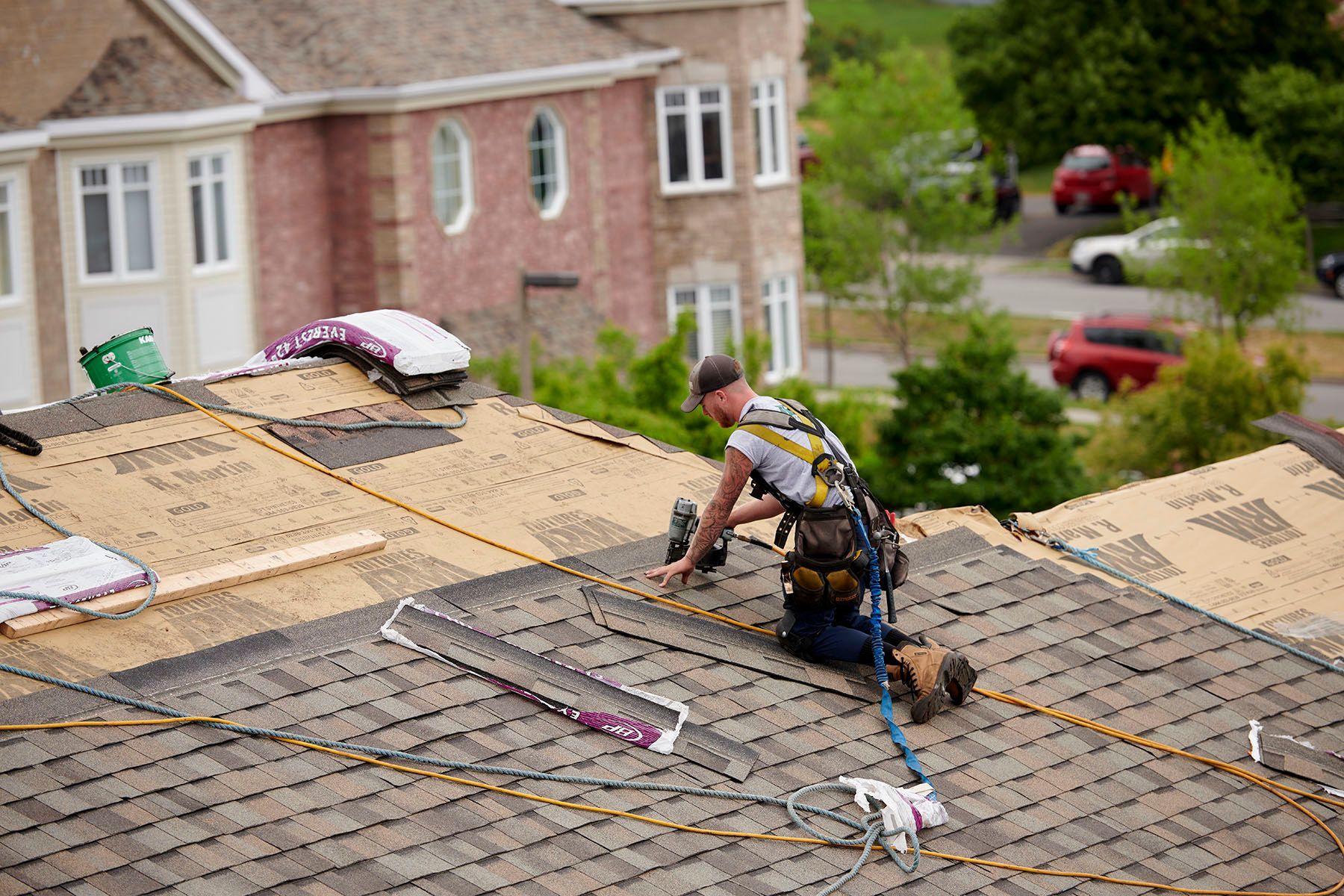 Un homme travaille sur le toit d'une maison.