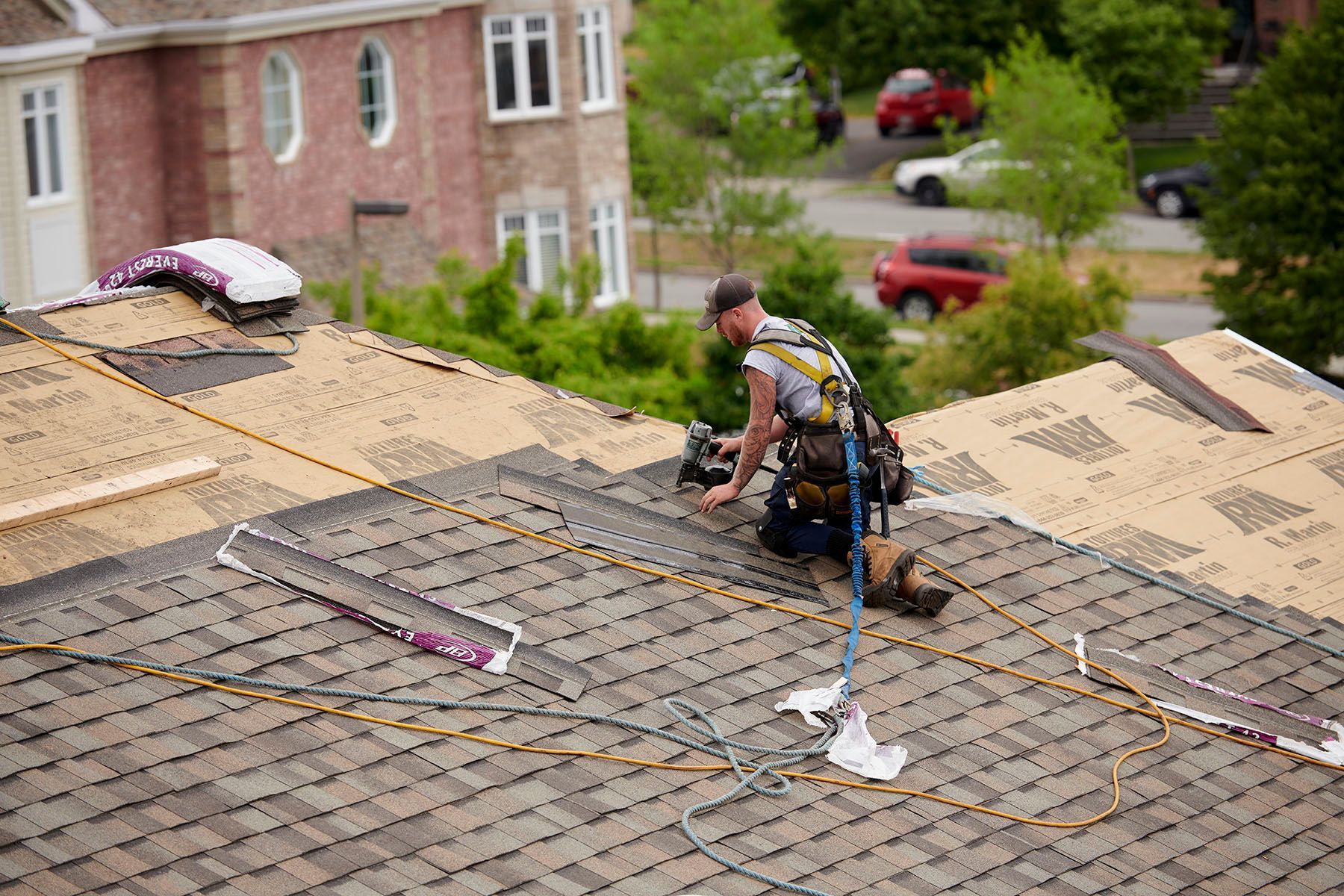 Un homme travaille sur le toit d'une maison.