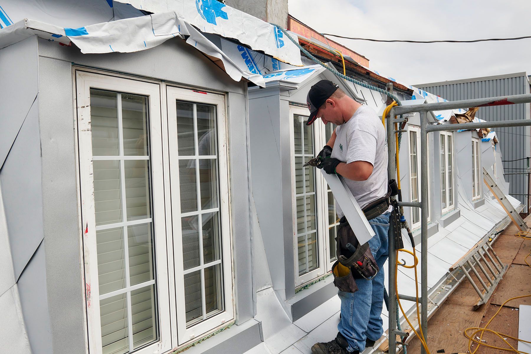 Un homme travaille sur le toit d'un immeuble.