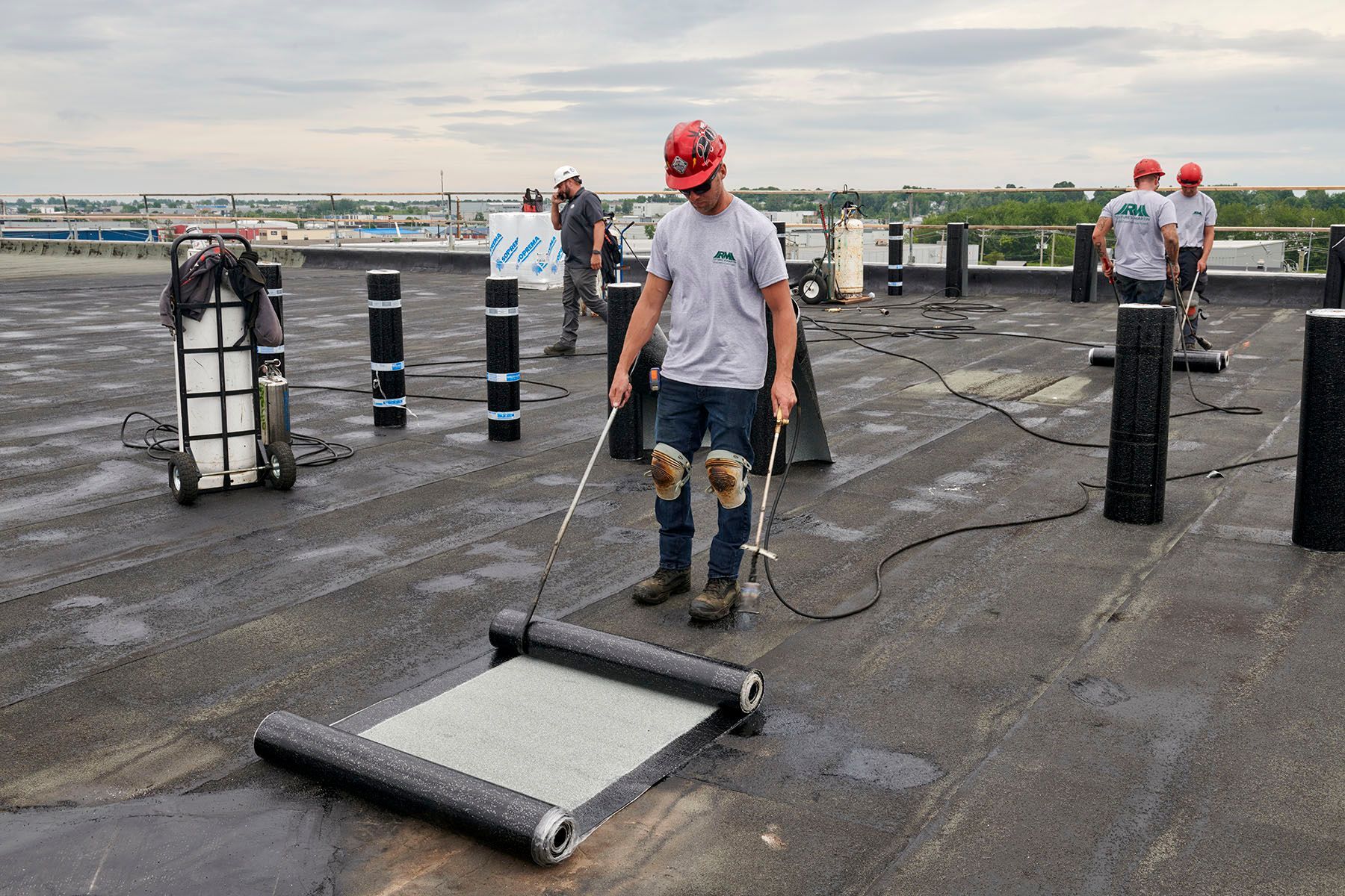 Un groupe d'hommes travaillent sur un toit.