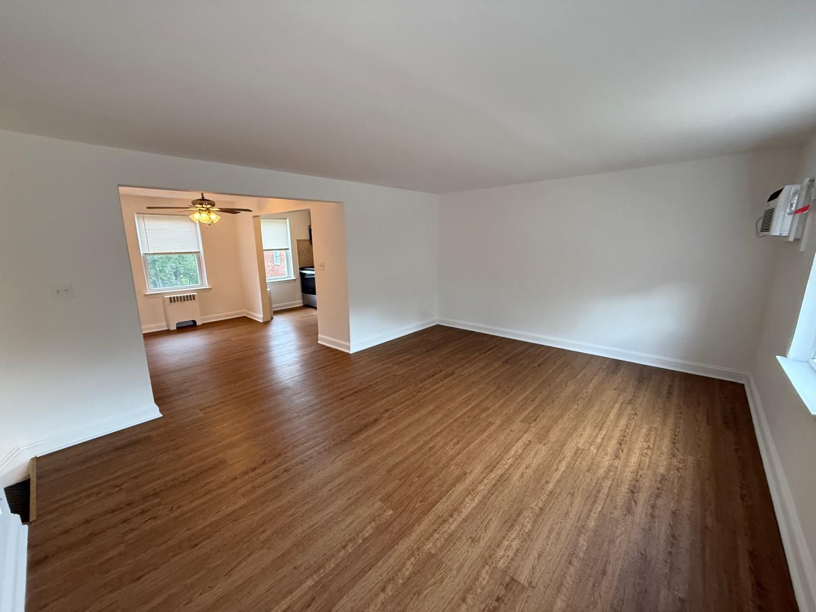 Open living space with wood floors and view into dining area