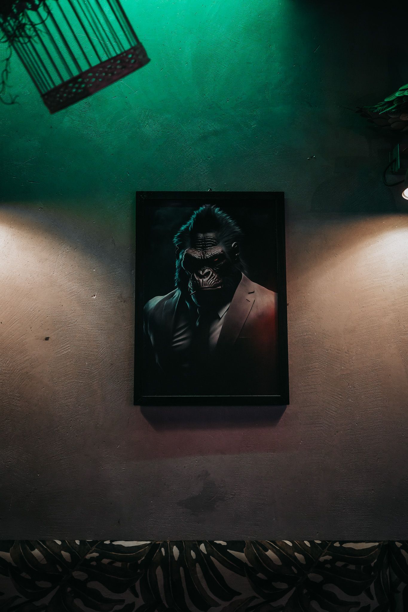 Dipinto di una figura con capelli lunghi e abiti scuri su una parete strutturata, con illuminazione verde e arancione.